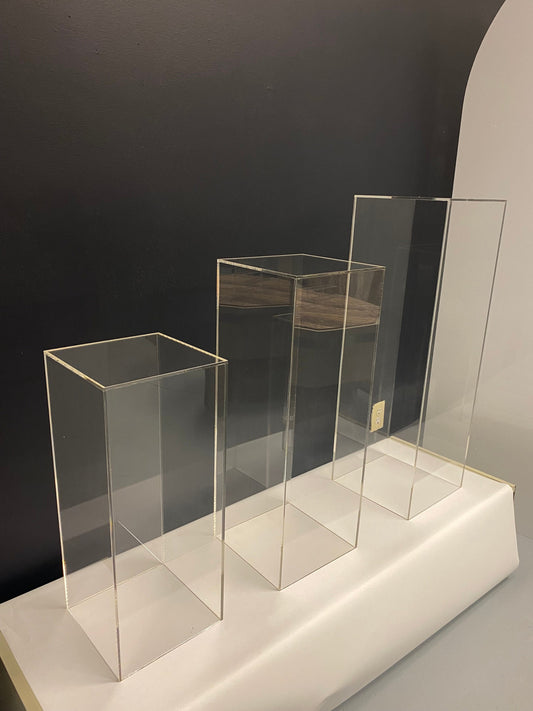 Three clear acrylic display pedestals in graduated heights for product, cake and sculpture display